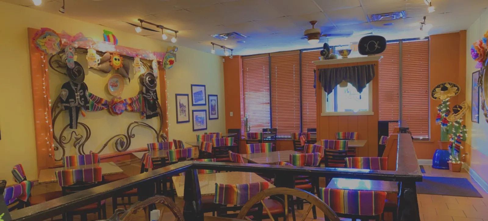 El Coyote's colorful dining room with striped chairs and yellow and orange walls